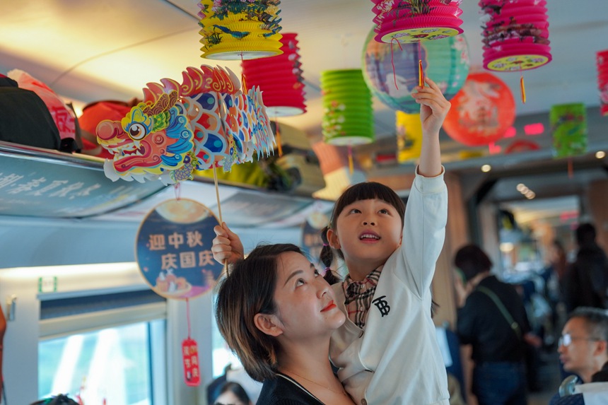 重慶西開往貴陽北的G4859次列車上，旅客打卡中秋國慶文化車廂。李文航攝